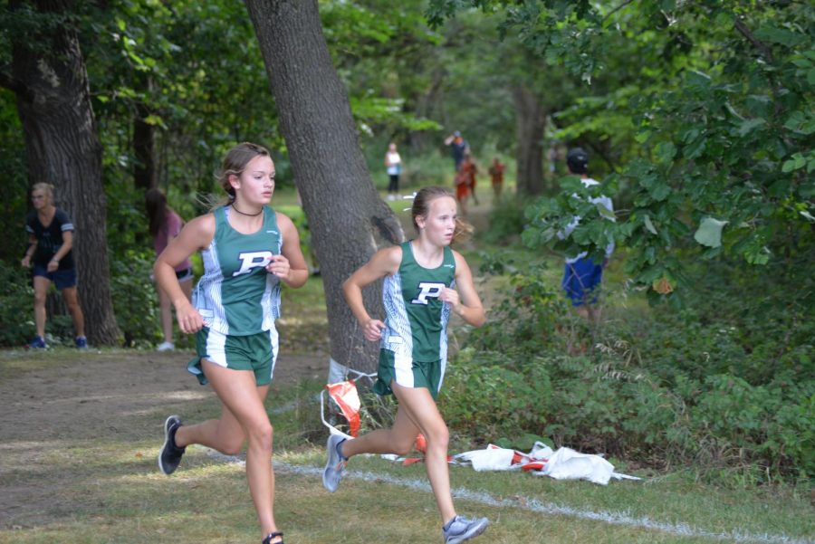Freshmen Abby Teagarden and Tess Paulsen running together halfway through the course at Central. (Bryleigh De Jong)