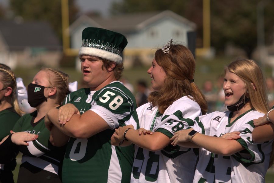 Homecoming King Cole DeWaard and Queen Annika Boonstra cheer along with the cheerleaders. 