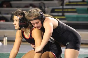Freshman Elizabeth Thomas wrestles during our glow in the dark night at Pella. Wrestling at 130 against her opponent from Newton! It was a tough match. She knew what she was doing, and she knew how to use her hips and move me where she wanted me to go, said Thomas.