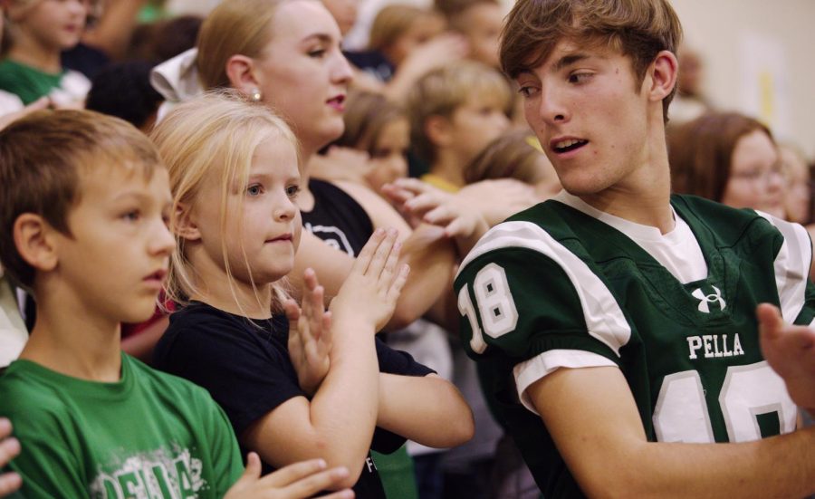 Senior Leyton Bethards looks at his younger sister while doing a cheer.